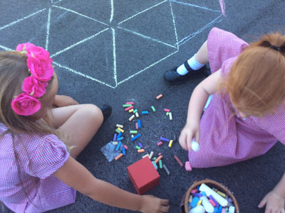 Children drawing in chalk in playground